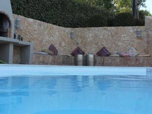 a swimming pool in front of a stone wall at Luxurious Villa in Silves with Swimming Pool in Nora