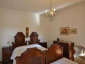 Un dormitorio con una gran cama de madera y una lámpara de araña. en Lovely Holiday Home with Pool in Monte Colombo, en Monte Colombo