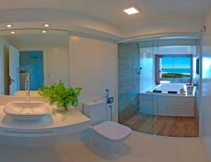 a bathroom with a toilet and a shower and a sink at Pousada Morada dos Sisais in Praia do Rosa