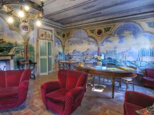 Gualdo CattaneoにあるBelvilla by OYO Glicineのテーブルと椅子、壁画が備わる客室です。