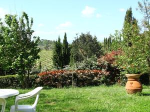 a table and chairs in a yard with a vase at Belvilla by OYO Da Vinci Due in Vinci