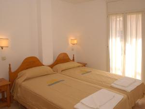 a bedroom with two beds and a window at Belvilla by OYO Comte de Empuries Apt C in Empuriabrava