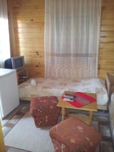a room with a bed with a table and two stools at Zlatnoto Pile Restaurant & Rooms in Kranevo