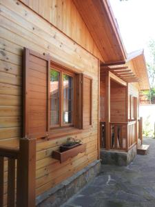 a wooden house with windows on the side of it at Zlatnoto Pile Restaurant & Rooms in Kranevo