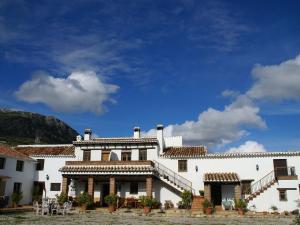 Belvilla by OYO Cortijo las Monjas في Periana: مبنى أبيض كبير مع سماء زرقاء في الخلفية
