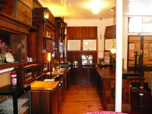 a kitchen with wooden cabinets and a counter top at Madam Saddler - On Fraser Clunes in Clunes