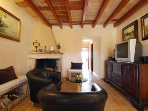 a living room with leather chairs and a fireplace at Belvilla by OYO Ca Na Patufa in Alcudia