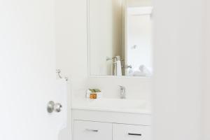 a white bathroom with a sink and a mirror at Ballarat Colonial Motor Inn in Ballarat