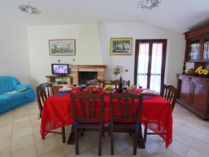 a dining room with a red table and chairs at Belvilla by OYO Giulio in Acqualagna