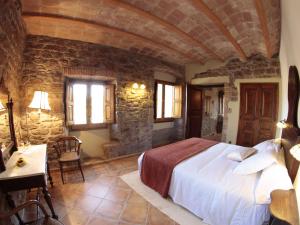 een slaapkamer met een groot bed en een stenen muur bij Belvilla by OYO El Puig de Vilapost in Balsareny