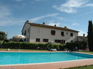 a house with a swimming pool in front of a building at Spacious Farmhouse in Pienza with Swimming Pool in Contignano