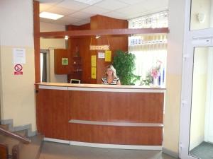 a woman sitting at a counter in a waiting room at Hotel Labe in Litoměřice