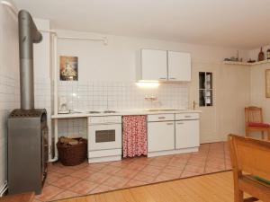 a kitchen with white appliances and a tile floor at Spacious Holiday Home in Menkhausen near Ski Area in Schmallenberg