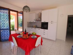 アックアラーニャにあるBelvilla by OYO Giammyのキッチン(テーブル、赤いテーブルクロス付)
