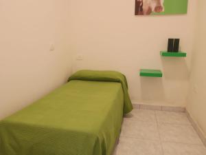 a small bedroom with a green bed in a room at Belvilla by OYO Giammy in Acqualagna