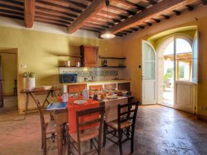 een keuken met een tafel en stoelen en een keuken met een tafel en een keuken bij Belvilla by OYO Ginestrilo in Assisi