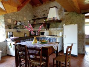 uma cozinha com uma mesa com cadeiras e um frigorífico em Belvilla by OYO Val Di Lima Romantica em Cocciglia