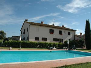 una casa con piscina frente a un edificio en Authentic farmhouse in the Val D Orcia with pool and stunning views, en Contignano