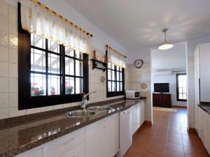 eine Küche mit einem Waschbecken und zwei Fenstern in der Unterkunft Belvilla by OYO Casa Loli in Algarrobo-Costa