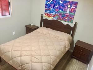 a bedroom with a bed and a painting on the wall at Desiderata in Punta Del Diablo