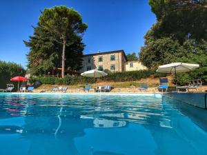 einen Pool mit Stühlen und Sonnenschirmen in der Unterkunft Belvilla by OYO Marchese in Gualdo Cattaneo