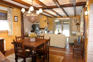 a dining room and living room with a table and chairs at Complejo Rural El Marañal in Caspueñas