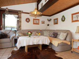 a living room with a couch and a table at Holiday home on Lake Henne with terrace in Meschede