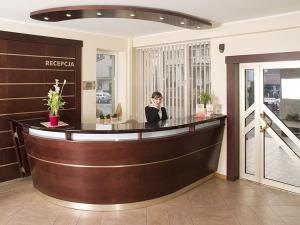 kobieta siedząca w barze w holu w obiekcie Hotel Vega w mieście Lębork