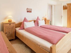 a bedroom with two beds with red and white sheets at Apartment near the Feldberg ski area in Dachsberg im Schwarzwald