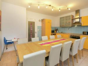 a kitchen with a wooden table and white chairs at Cozy Holiday Home in Niedersalwey with Sauna in Eslohe