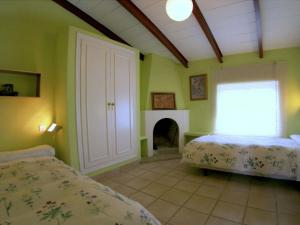 1 dormitorio con 2 camas y chimenea en Belvilla by OYO Casa Candela, en Ronda