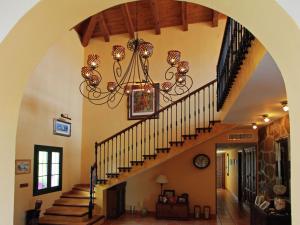 a hallway with a chandelier and stairs in a house at Belvilla by OYO Villa Los Chaparros in La Joya