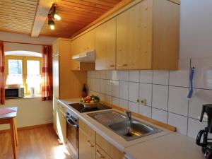 ヴィヒタッハにあるLovely Holiday Home in Viechtach near the Forestのキッチン(木製キャビネット、シンク付)