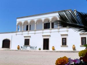 Belvilla by OYO Tramonto di Salento grande في توريشيلا: مبنى أبيض بأبواب ونوافذ سوداء