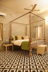 a bedroom with a canopy bed with a fan at The Ivy House in Kolkata