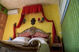 Schlafzimmer mit einem Bett mit rotem Baldachin in der Unterkunft Katerina's Studios in Kardhamili