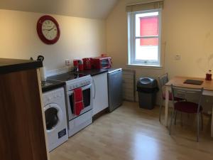 a kitchen with a stove and a washing machine at 6 Varis Apartments in Forres