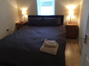 een slaapkamer met een groot bed met een handdoek erop bij 6 Varis Apartments in Forres