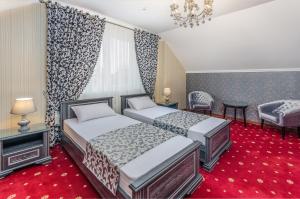 a hotel room with two beds and a chandelier at Park Lane Hotel in Chişinău