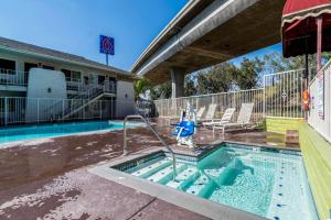 a swimming pool with chairs next to a building at Motel 6-Redlands, CA in Redlands
