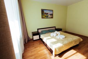 una camera da letto con un letto e due asciugamani di Apart Hotel Clover a Irkutsk