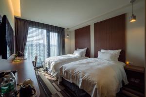 Postel nebo postele na pokoji v ubytování Watermark Hotel Kaohsiung Main Station