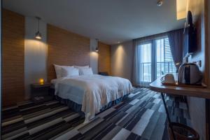 Postel nebo postele na pokoji v ubytování Watermark Hotel Kaohsiung Main Station