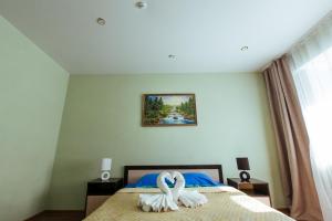 un dormitorio con dos cisnes sentados en una cama en Apart Hotel Clover, en Irkutsk