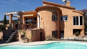 a house with a swimming pool in front of it at L'Ecureuil de l'Estérel in Saint-Raphaël