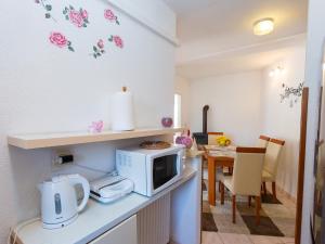 a kitchen with a microwave on a counter with a table at Apartments Špadići in Poreč