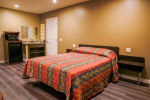 a hotel room with a bed and a sink at Newport Bay Inn in Costa Mesa