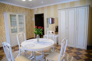a dining room with a table and chairs with a vase of flowers at Hotel Hizhina in Petropavlovsk +59 photos