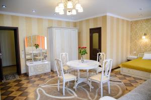 a room with a table and chairs and a bed at Hotel Hizhina in Petropavlovsk