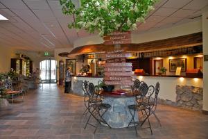 a table and chairs in a lobby with a directional sign at Vakantiehotel Der Brabander Apartments in Winterberg
